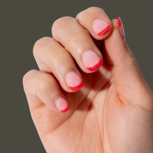 A picture of girlss hand having Short Square Red French Tip Nails